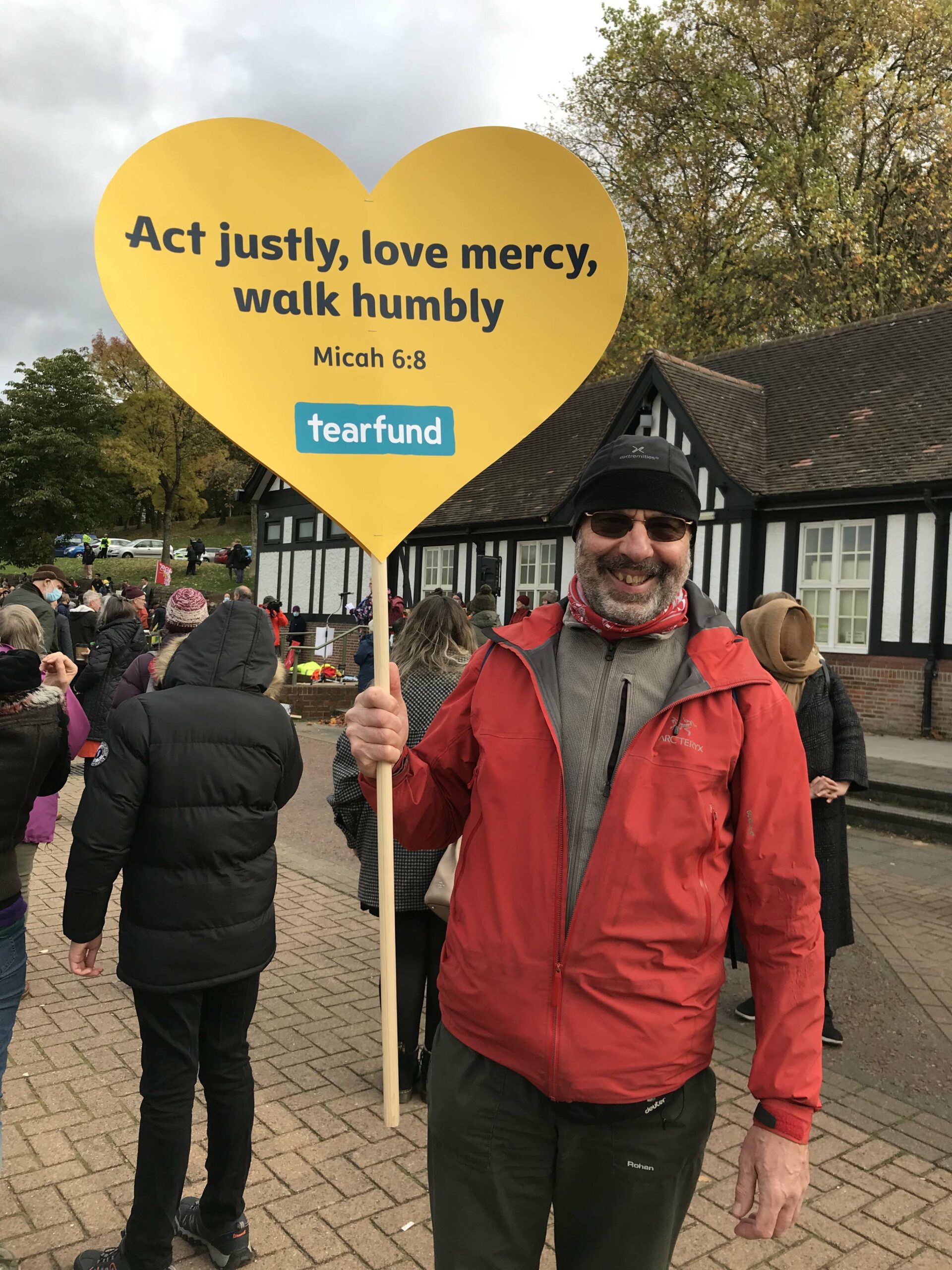 man holding sign 'act justly, love mercy, walk humbly' Micah 6:8